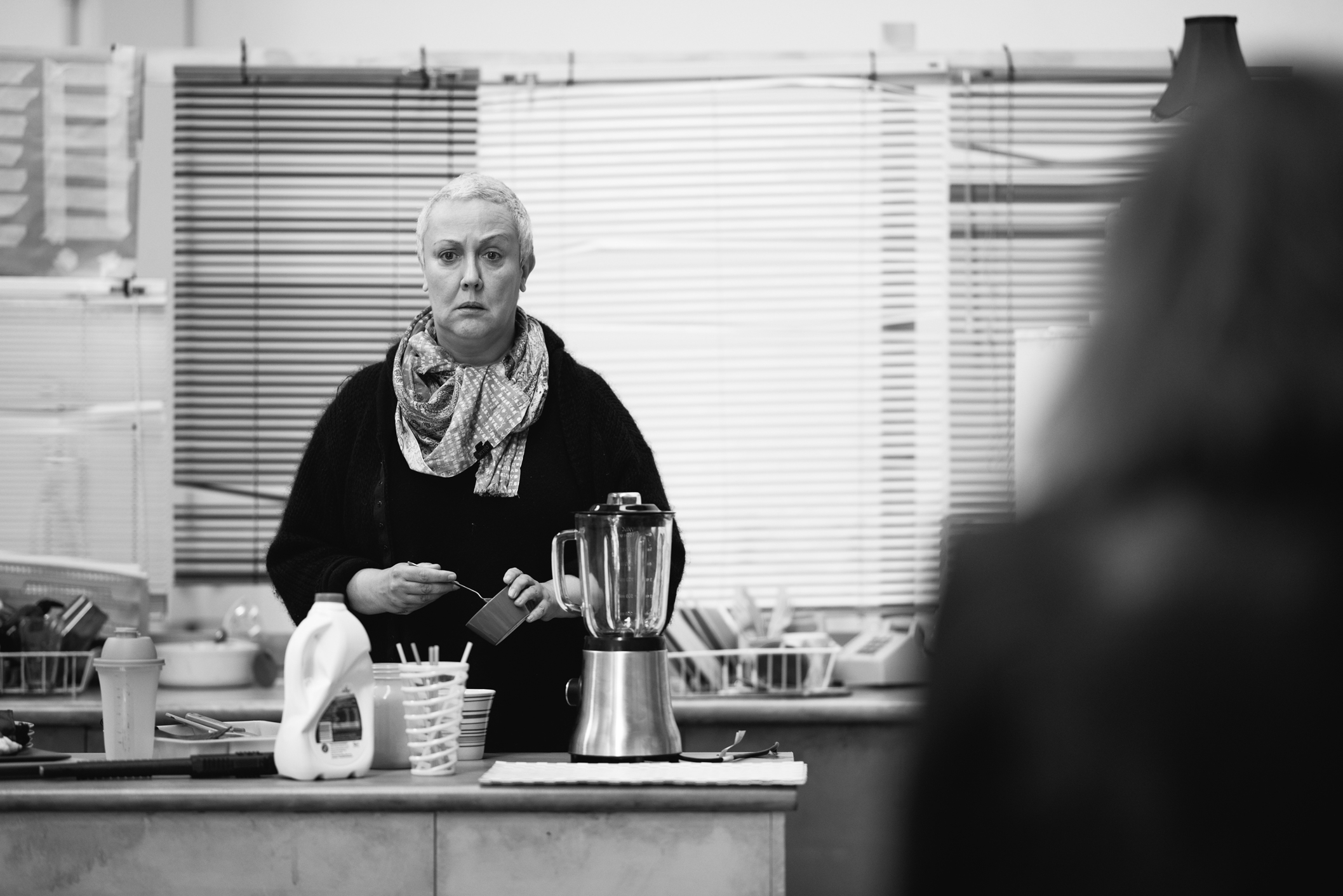 Rima Te Wiata stands contemplative, spooning from a sugar bowl.